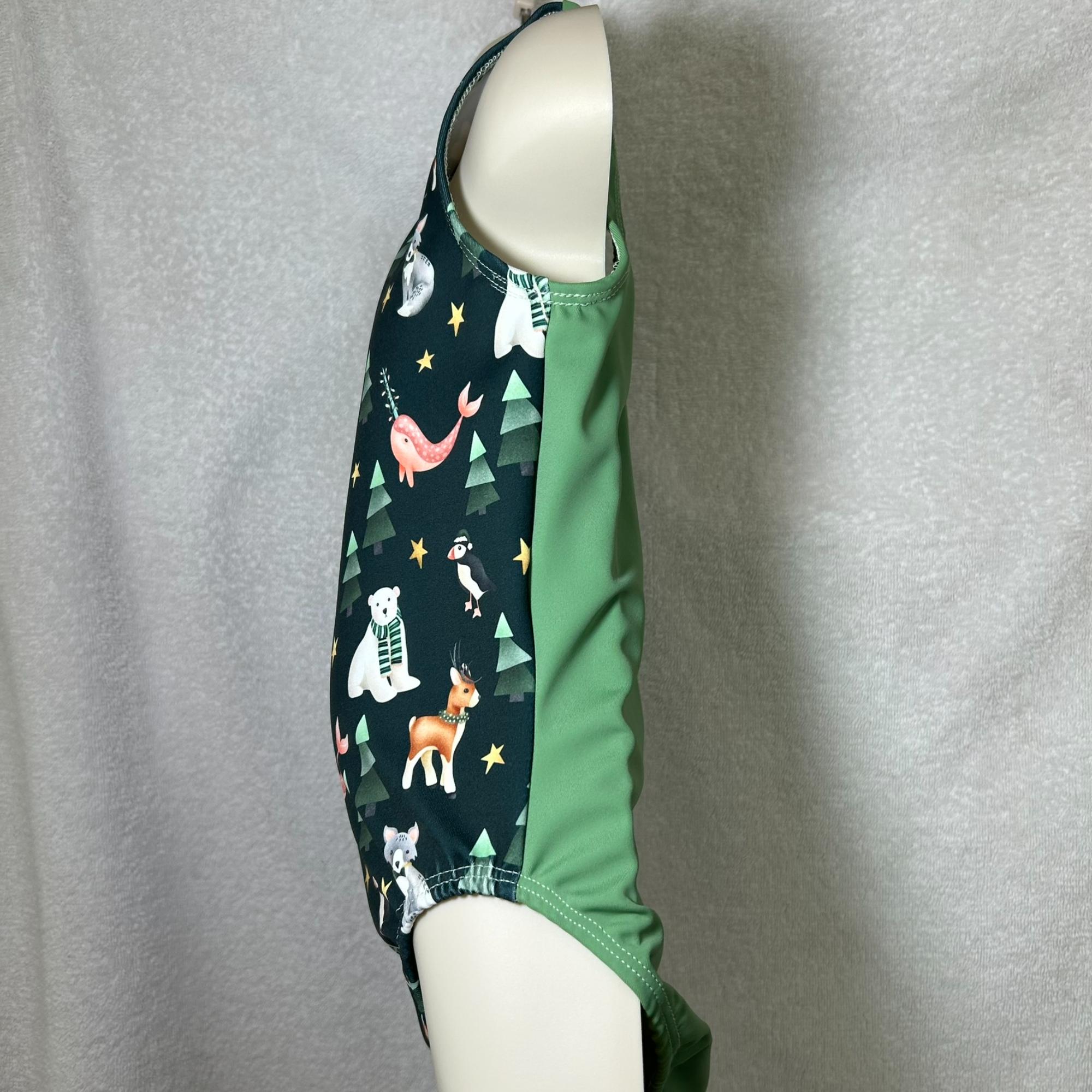 Side view of leotard, front has cute holiday animals and solid sage green back