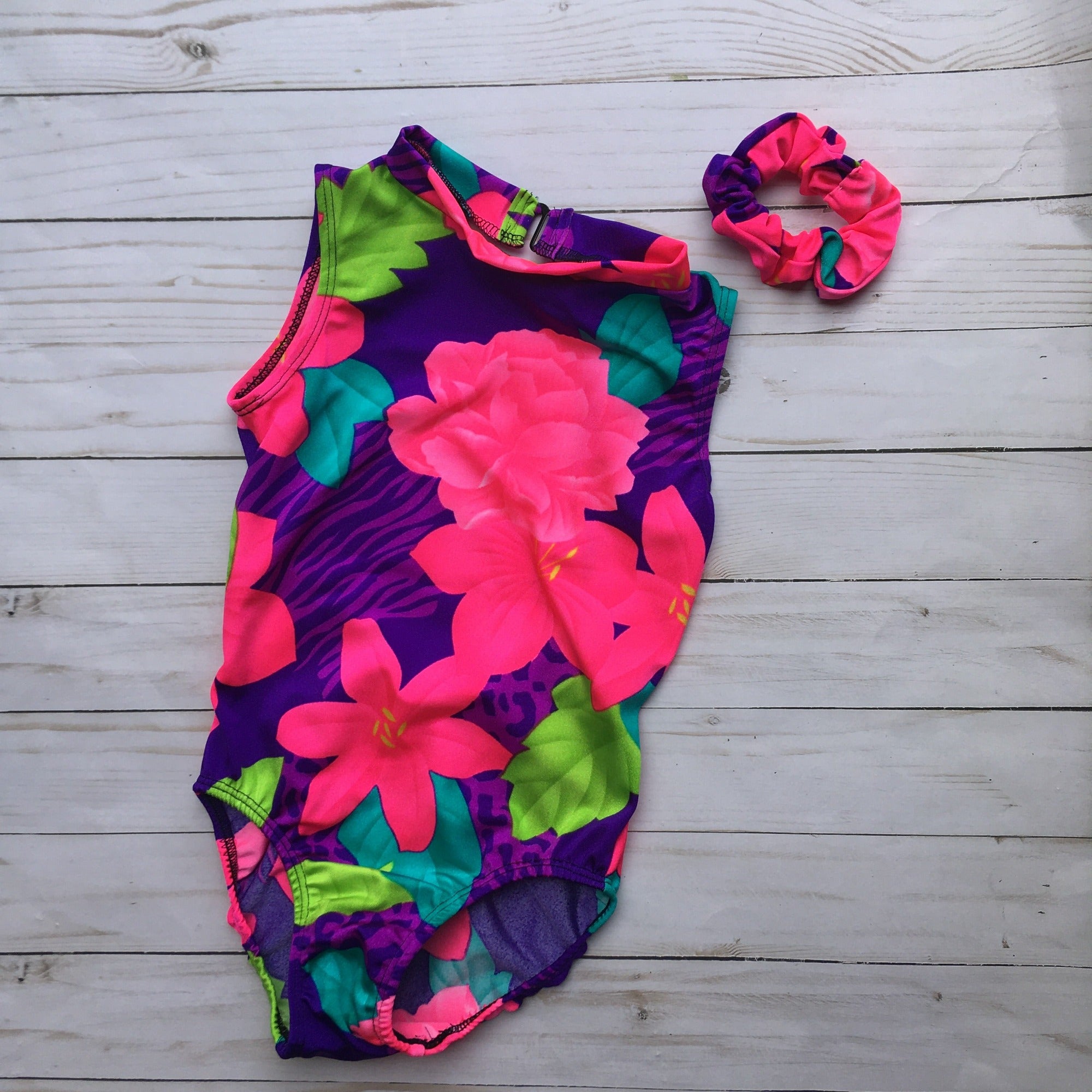 Leotard with hot pink flowers, green & turquoise leaves on a purple background